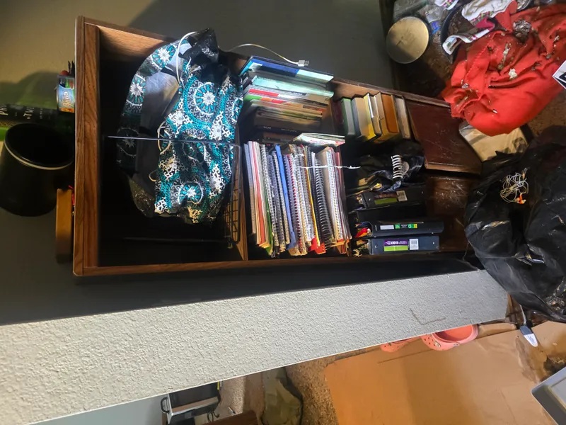 Room before junk removal — clothes, furniture, and debris